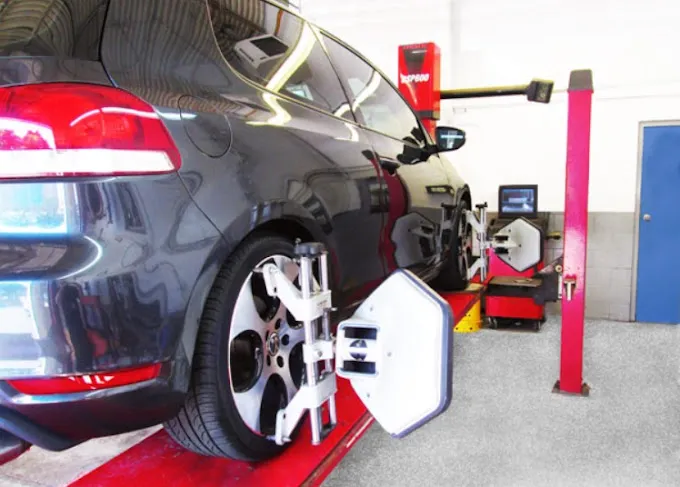 Mechanic performing a brake inspection on a car in a well-equipped workshop