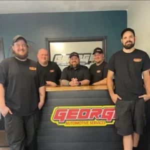 Happy customers sharing positive experiences with mechanics in an auto repair shop