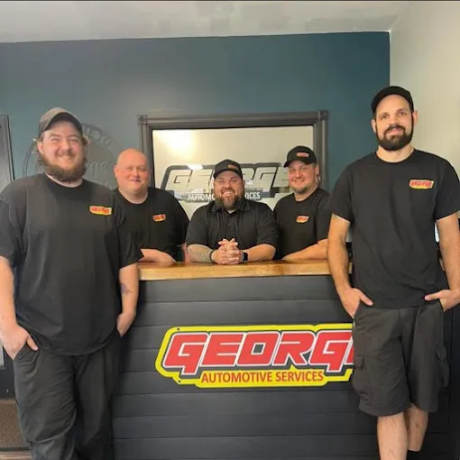 Happy customers sharing positive experiences with mechanics in an auto repair shop